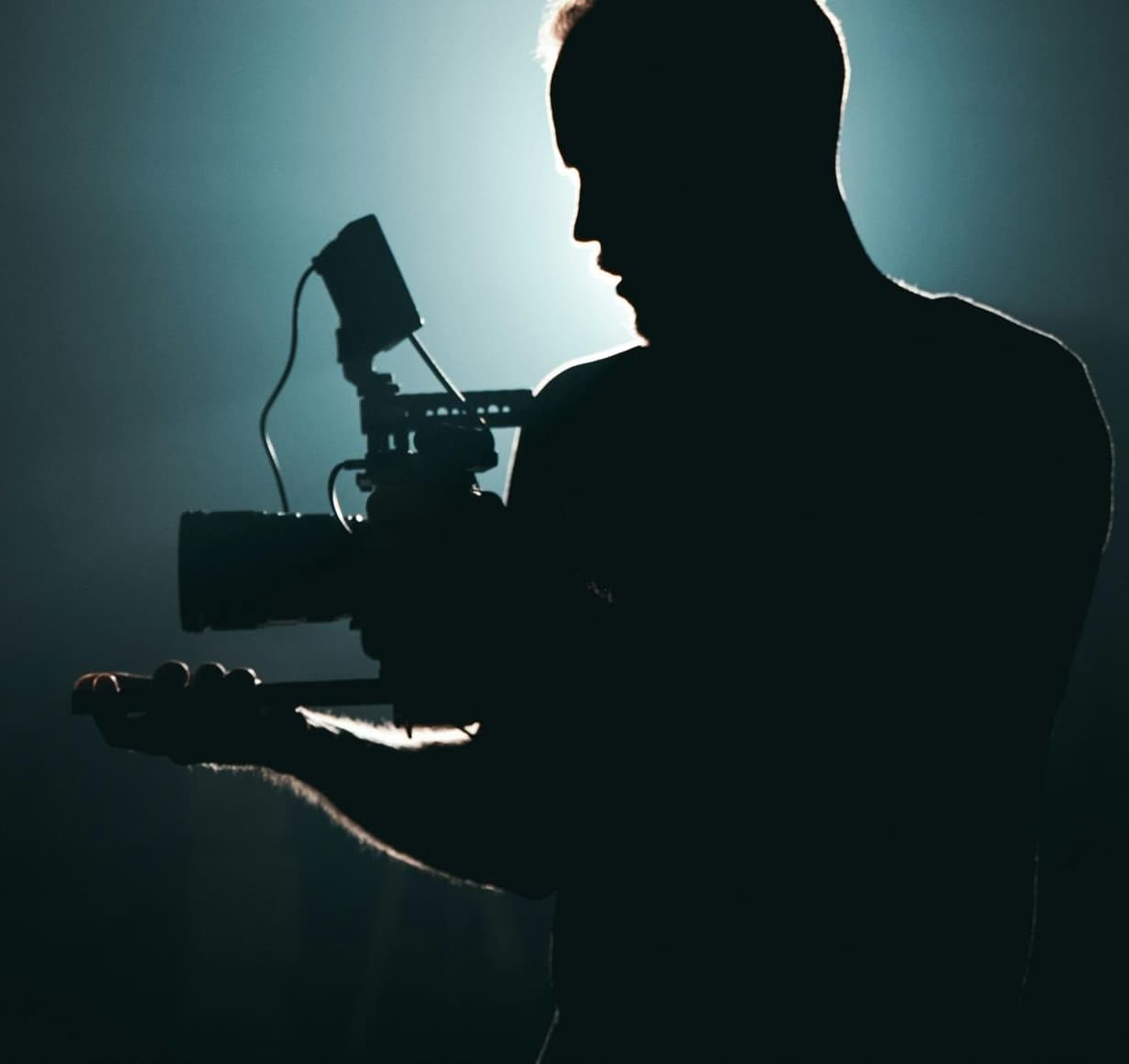 A behind-the-scenes studio still with lighting stands and gear in warm tones.
